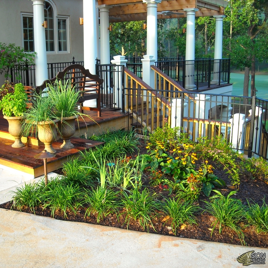 Landscape design featuring structured planting beds and stone steps.
